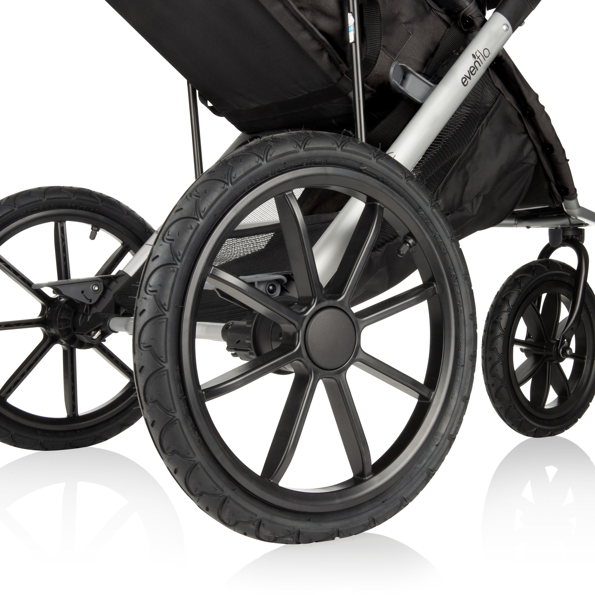 A close-up view of the large, sturdy wheels of an Evenflo jogging stroller, designed for all-terrain use.