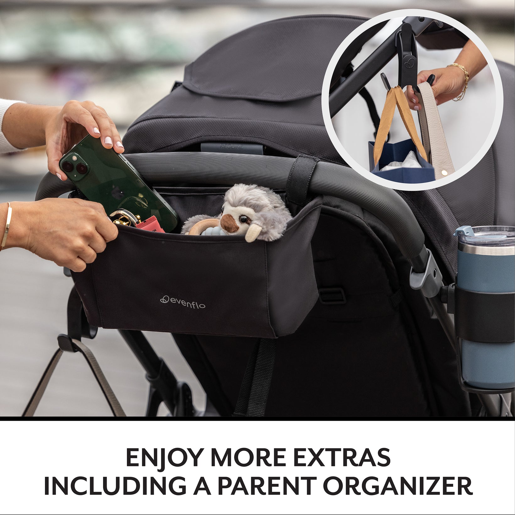 Black stroller organizer with phone, cup, and toy attached, featuring Evenflo branding.