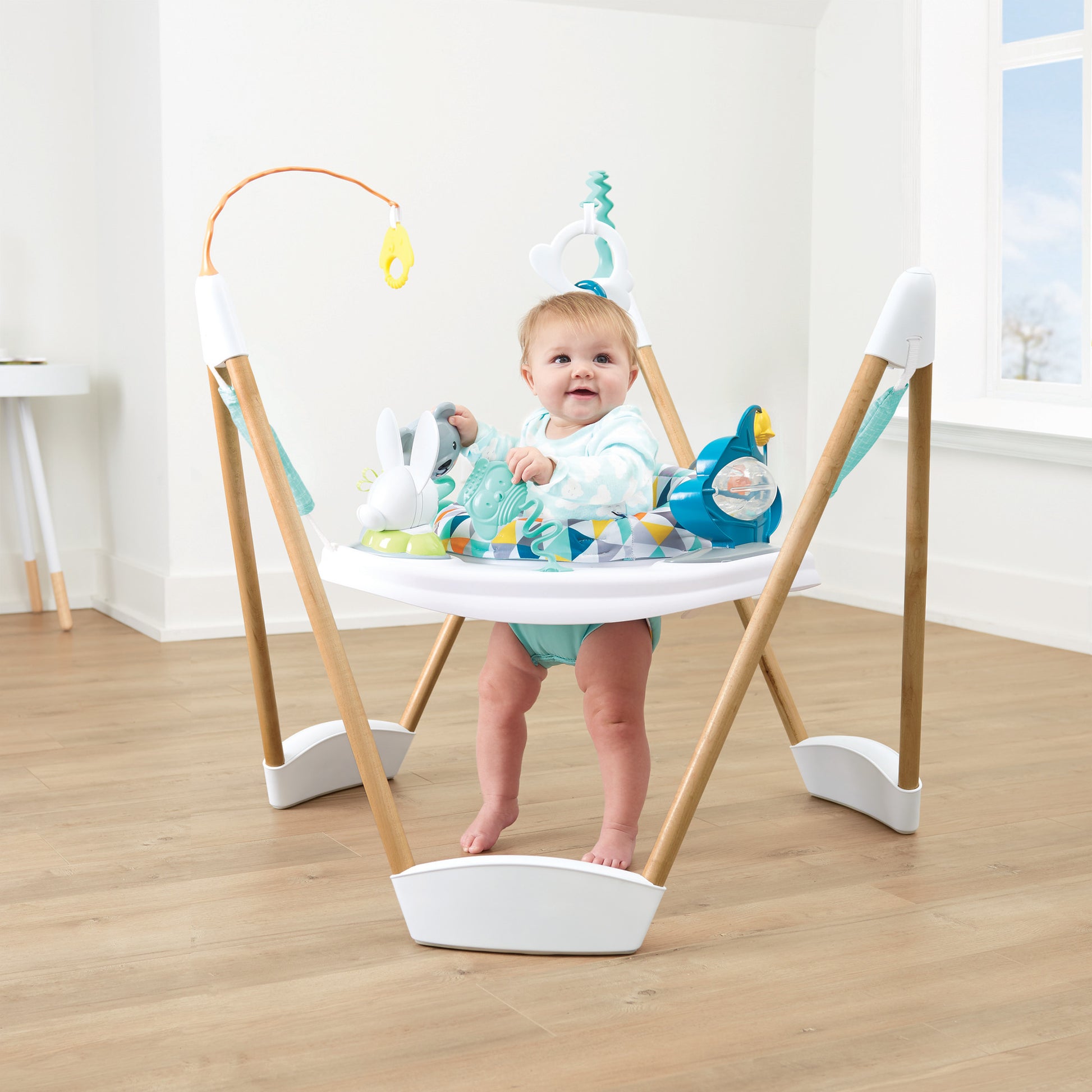 Delighted baby bouncing and playing in an Evenflo ExerSaucer activity center.