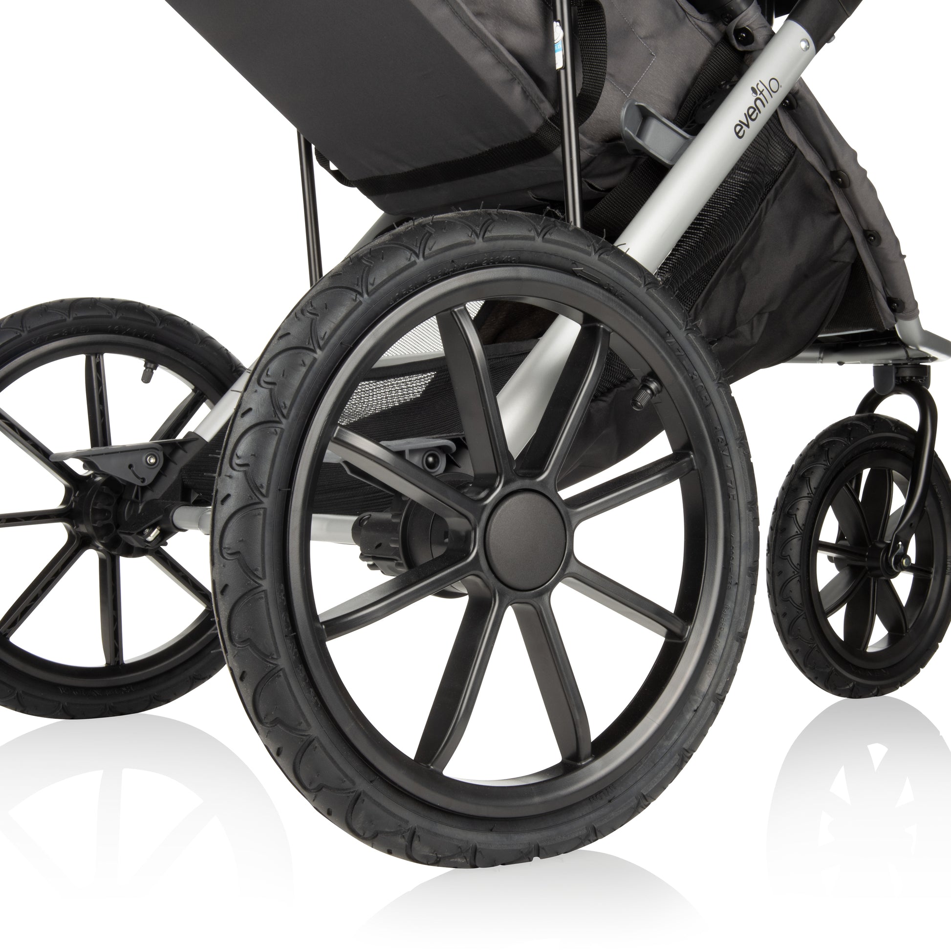 Close-up of the large, all-terrain wheels of an Evenflo jogging stroller.