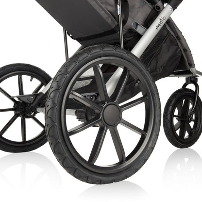 Close-up of the large, all-terrain wheels of an Evenflo jogging stroller.