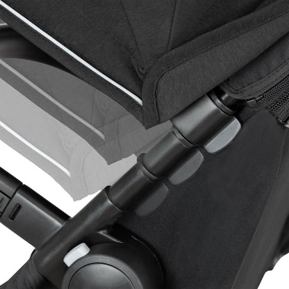 Close-up of a black stroller with a focus on the handle and seat area.