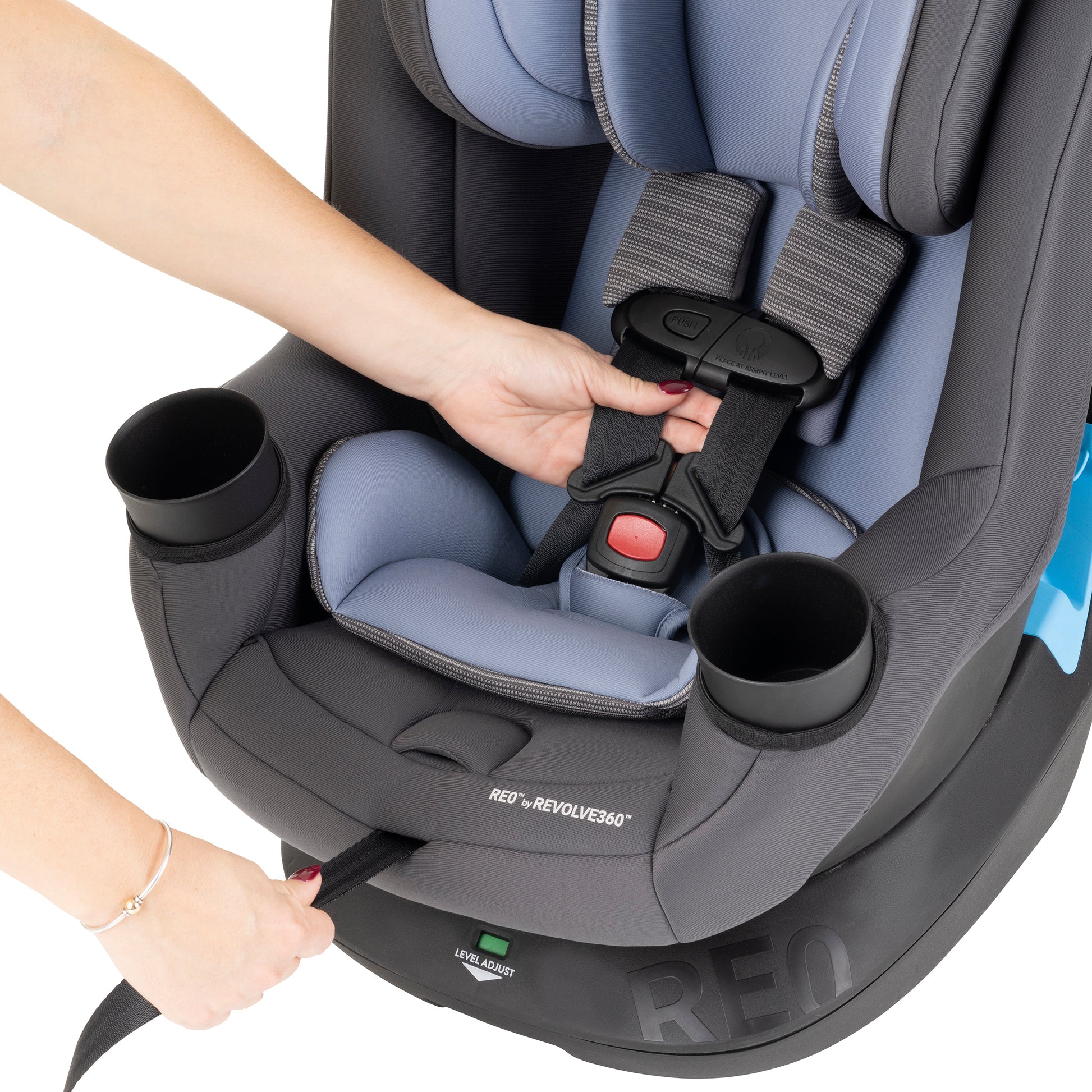Child car seat with cup holders and straps being adjusted.