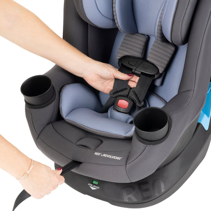 Child car seat with cup holders and straps being adjusted.