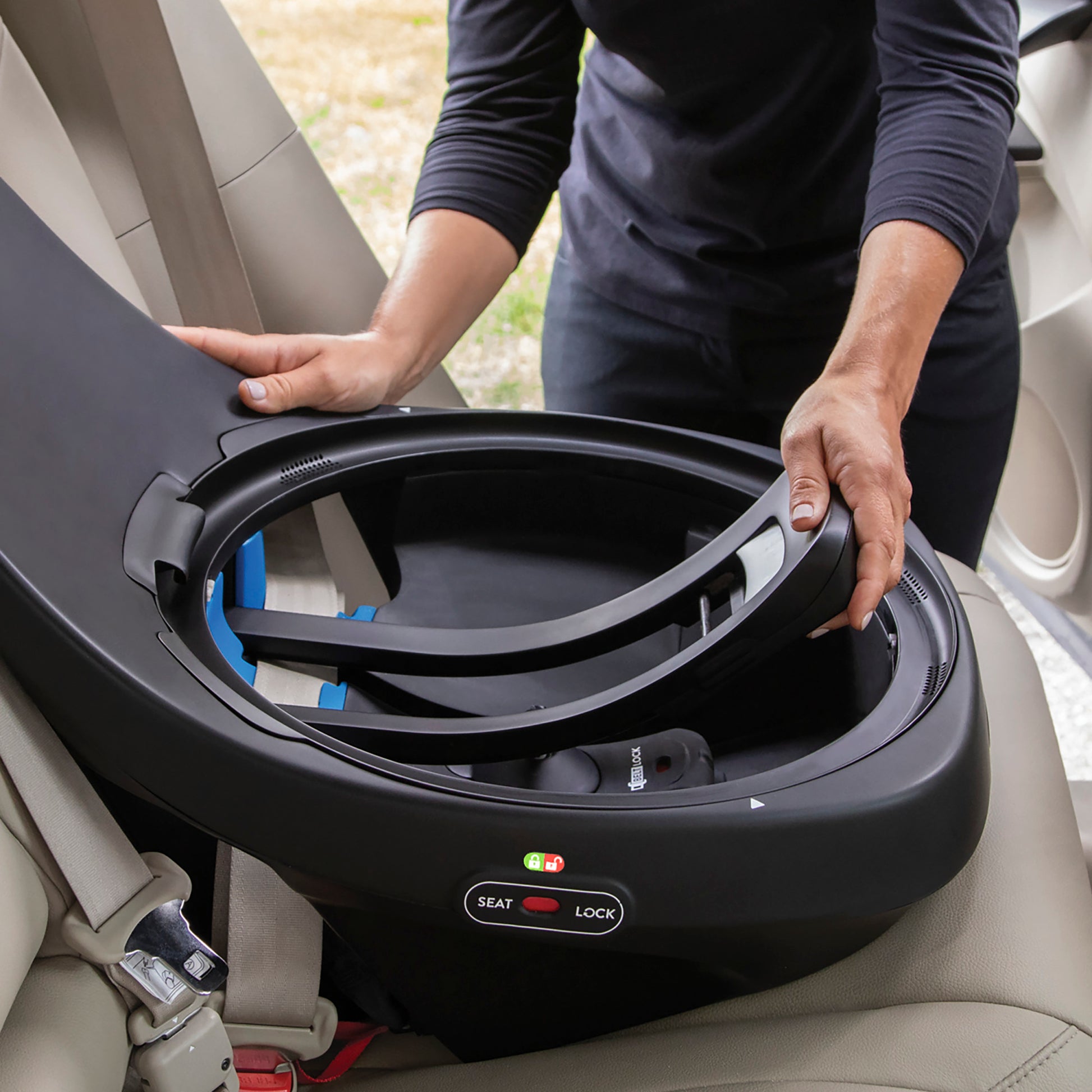 Person opening the base of an Evenflo Revolve360 Extend car seat to install it.